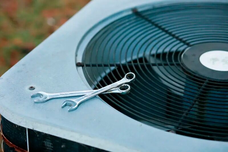 Smith air conditioning repair and maintenance with tools on a condenser unit