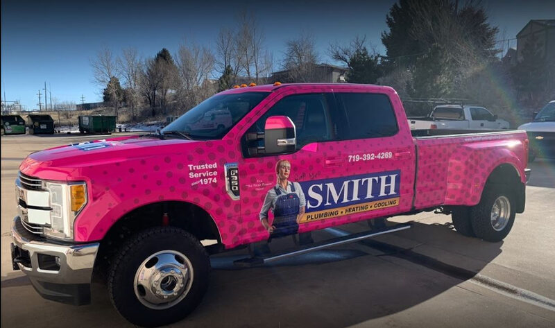 A Smith pink Ford F-350 dually service truck with Eva, The Polish Plumber branding